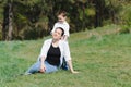 Happy young mother is playing with her baby in a park on a green lawn. Happiness and harmony of family life. Great family vacation