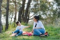 Happy young mother is playing with her baby in a park on a green lawn. Happiness and harmony of family life. Great family vacation