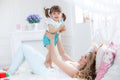 Happy young mother playing with her daughter on the bed at home Royalty Free Stock Photo