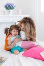 Happy young mother playing with her daughter on the bed at home Royalty Free Stock Photo