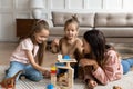 Happy young mother playing with two daughters on warm floor Royalty Free Stock Photo
