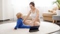 Happy young mother taking care of her baby son and doing fitness exercises and stretching with him. Family healthcare, active Royalty Free Stock Photo