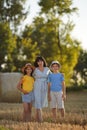 A happy young mother with teenage children stand in nature, a mother hugs the children and smiles happily, happy family Royalty Free Stock Photo