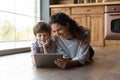 Happy young mother using tablet with little kid. Royalty Free Stock Photo