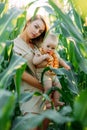 Young mother walks with her baby among cornfield Royalty Free Stock Photo