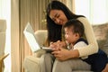 Happy young mother working remotely on laptop while taking care of her baby Royalty Free Stock Photo