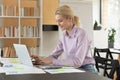 Happy young motivated female employee working on computer.