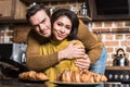 happy young multiethnic couple embracing and smiling at camera during breakfast Royalty Free Stock Photo