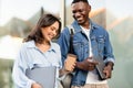 Happy young multiracial couple walking by street, talking and laughing Royalty Free Stock Photo