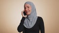 Happy young muslim woman making pleasant mobile phone call conversation with good friend or family Royalty Free Stock Photo