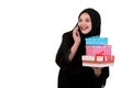 Happy young muslim woman with shopping bag and gift boxes isolated over white background Royalty Free Stock Photo