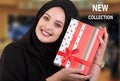 Happy young muslim woman with shopping bag and gift boxes at shopping mall.