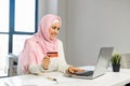 A young muslim woman wearing hijab using a laptop for online shopping Royalty Free Stock Photo