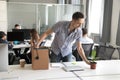 Happy young office worker, intern unpack belongings at workplace