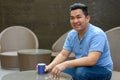 Happy young overweight Asian man drinking coffee at the coffee shop Royalty Free Stock Photo