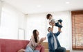 Happy young parents Caucasian father and Asian mother playing with little kid girl by holding cute baby fly in the air Royalty Free Stock Photo