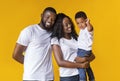 Happy young parents with cute little son over yellow background Royalty Free Stock Photo