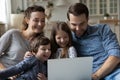 Happy young parents and little children using computer at home. Royalty Free Stock Photo