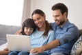 Happy young parents with little daughter watch cartoon on laptop Royalty Free Stock Photo