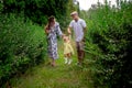 Happy young parents playing with their little baby girl at the green garden Royalty Free Stock Photo