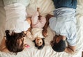 Happy young parents resting with their baby in the bedroom Royalty Free Stock Photo