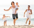 Parents with two kids jogging on beach Royalty Free Stock Photo