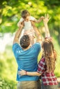 Happy young parrents throws up her little daughter in the park Royalty Free Stock Photo