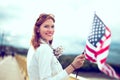 Young patriot modern woman holding USA flag looking back