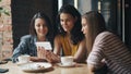 Happy young people watching funny content on smartphone screen in cafe laughing