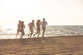 Happy young people group have fun white running and jumping on beach at sunset time Royalty Free Stock Photo
