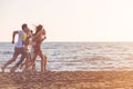 Happy young people group have fun white running and jumping on beach at sunset time Royalty Free Stock Photo