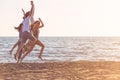 Happy young people group have fun white running and jumping on beach at sunset time Royalty Free Stock Photo