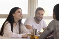 Group of friends sitting in cafeteria having pleasant conversation Royalty Free Stock Photo