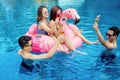 Happy young people holding drinks on pool