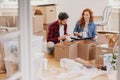Happy young people packing stuff into boxes while moving out fro Royalty Free Stock Photo