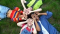 Happy young people showing ok gesture like binoculars lying campus park grass Royalty Free Stock Photo