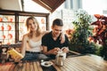 Happy young people sitting on terrace in cozy restaurant and smiling, young man and girl happy spending time together, wearing Royalty Free Stock Photo
