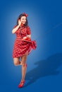 Happy young pinup standing woman talking on phone Royalty Free Stock Photo