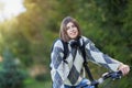 Happy young positive student going to school by bike