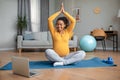 Happy young pregnant black woman with big belly sits in lotus position practices yoga and watches video workout Royalty Free Stock Photo