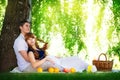 Happy and young pregnant couple hugging in nature enjoying summer park, outdoors, new life concept. Royalty Free Stock Photo