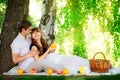 Happy and young pregnant couple hugging in nature enjoying summer park, outdoors, new life concept. Royalty Free Stock Photo