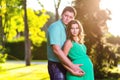 Happy and young pregnant couple hugging in nature Royalty Free Stock Photo