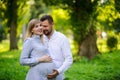 Happy and young pregnant couple hugging outdoor