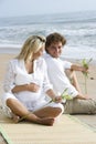 Happy young pregnant couple relaxing on beach Royalty Free Stock Photo