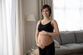 Happy pregnant woman in black underwear holding big baby bump Royalty Free Stock Photo