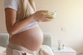 Happy young pregnant woman eating vegetable salad at home. Healthy nutrition and pregnancy concept. Expecting mother Royalty Free Stock Photo