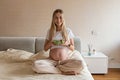 Happy young pregnant woman eating vegetable salad at home. Healthy nutrition and pregnancy concept. Expecting mother Royalty Free Stock Photo