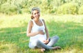 Happy young pregnant woman on grass doing yoga Royalty Free Stock Photo