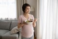 Happy young pregnant woman holding bowl with fresh vegetable salad Royalty Free Stock Photo